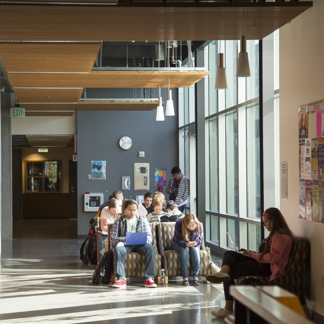 Students study in a lounge space inside an academic building on campus.