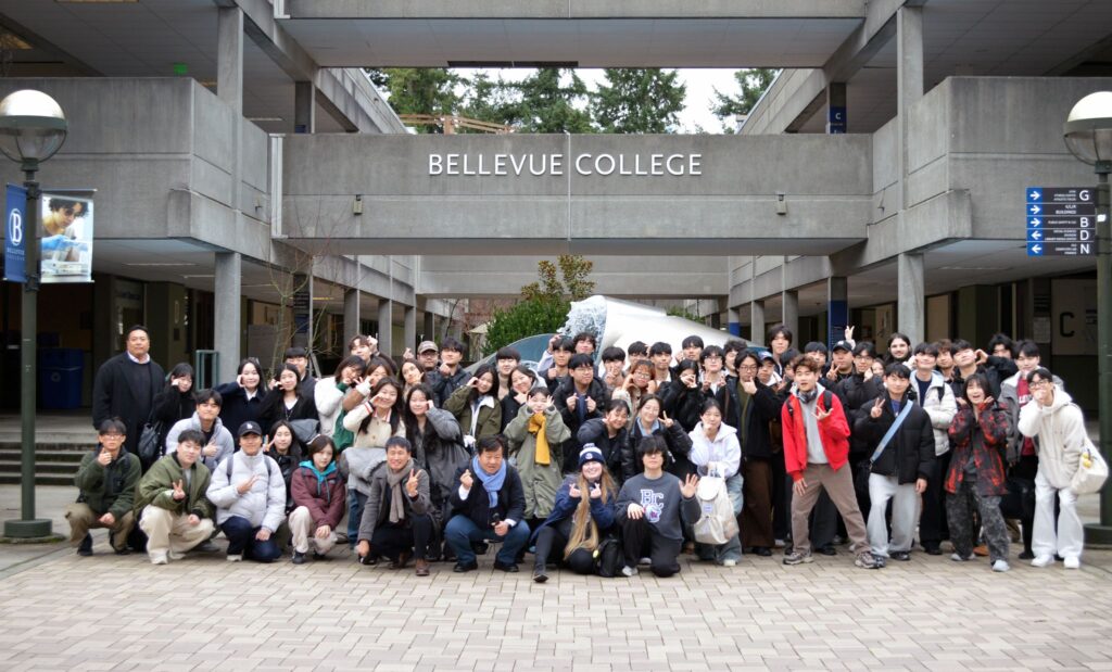 Delegation of South Korean students and faculty posing for a group photo in front of the Bellevue College fountain.