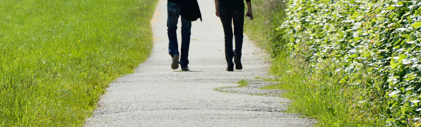 Two people walking along a path