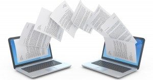 papers flying between two computers