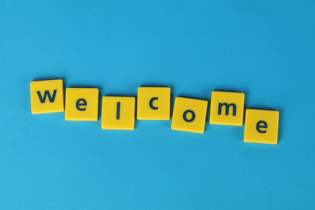 blue background with yellow tiles spelling welcome in black text