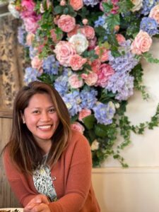 Catherine Lopez standing in front of big bouquet of flowers