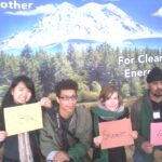 Group of Bellevue College students holding signs sitting down