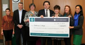 PSE holding big check to Bellevue College for lighting retrofits