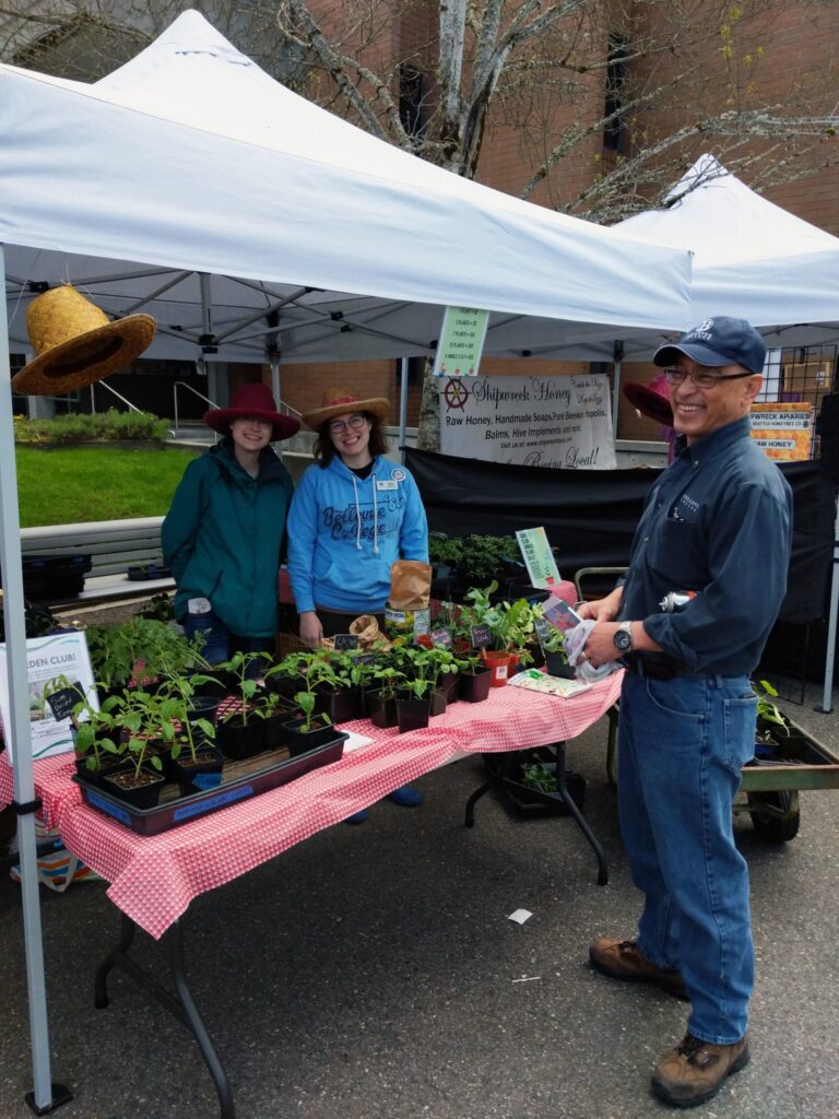 People around a garden club booth during a event