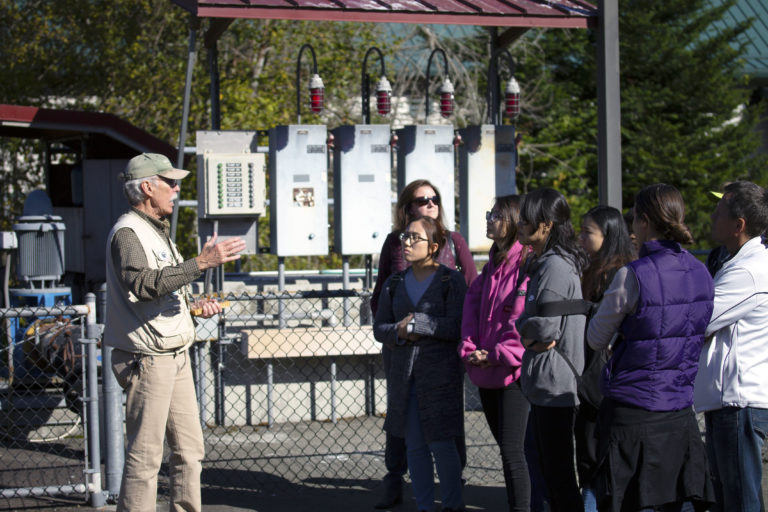 A tour guide talking to students during a sustainability field trip to the issaquah salmon hatchery