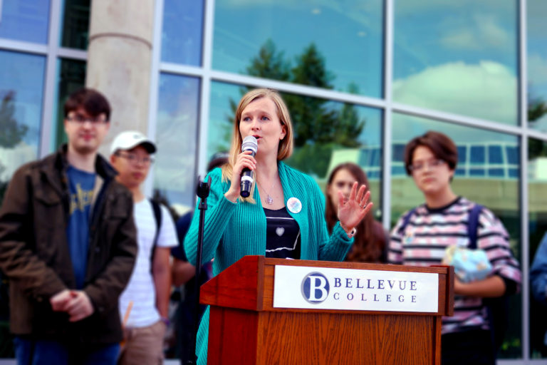 Bellevue College's director of sustainability speaking at a podium.