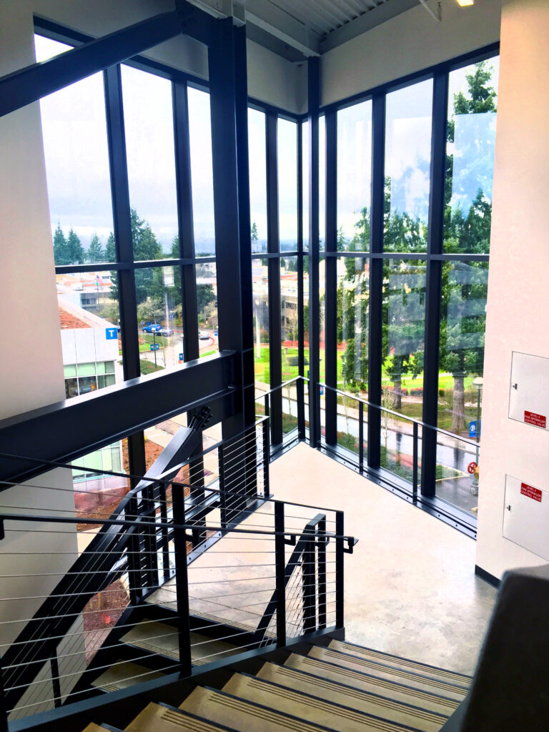 A staircase with window display viewing the rest of the campus at the student success center