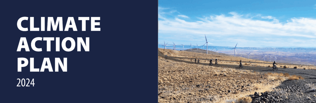 climate action plan 2024. Students riding bikes at wind horse farms with windmills behind them