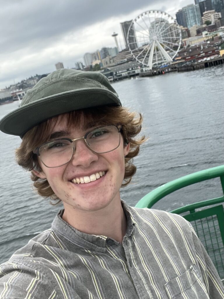 Student coordinator in front of the waterfront and Ferris wheel