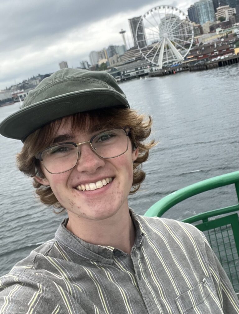 Student coordinator in front of the waterfront and Ferris wheel