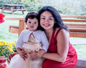 Sajonna Sletten posing on a bench with her child, both dressed up