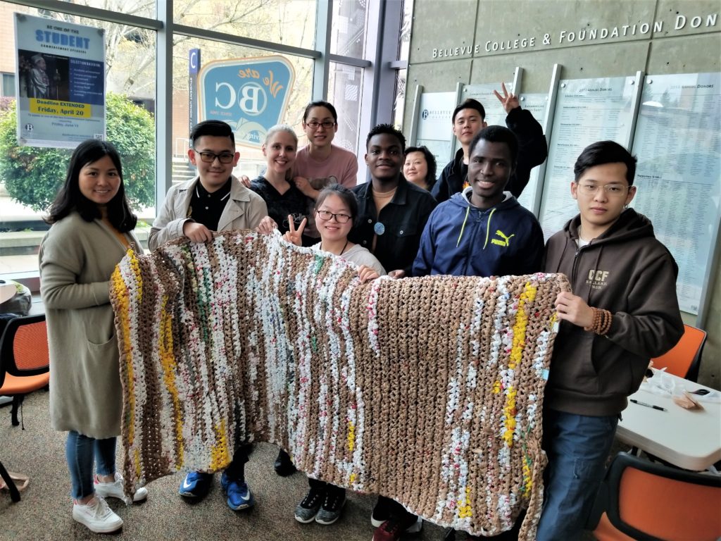 People holding up a mat made of plastic