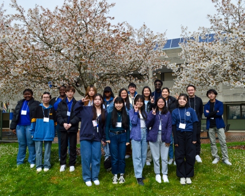 Student volunteers posing happily for camera with peace signs