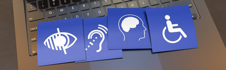 blue cards with accessibility symbols sitting on laptop
