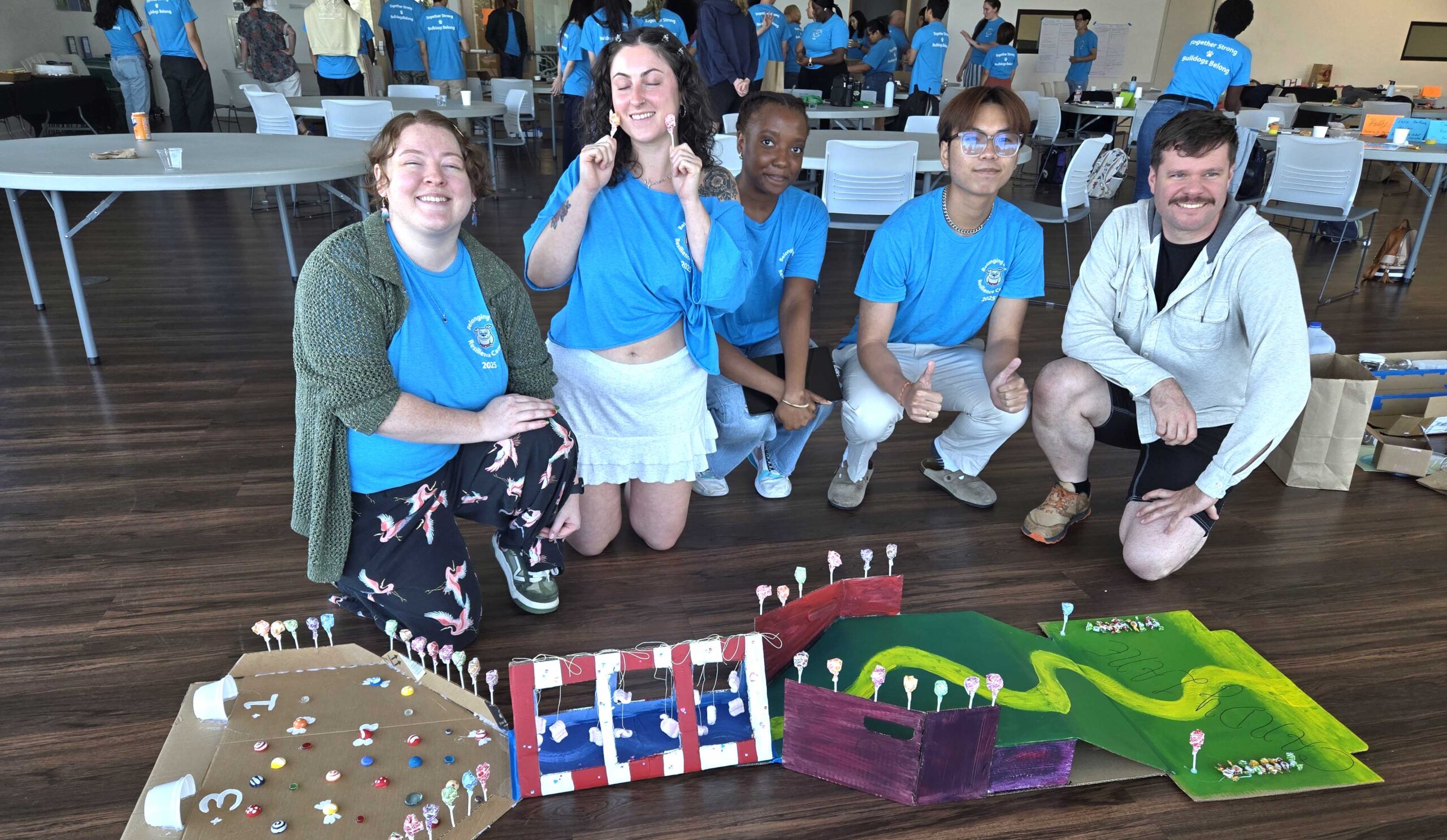 A team of students displaying their Paw Putt mini golf station based on Candy Lane.