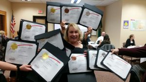 Sharon Berg surrounded by awards