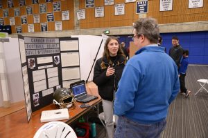 A woman talks to a man during the Science Fair