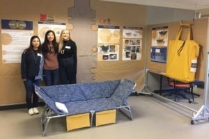 Three female studentsin a prototype shelter