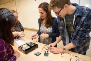 A professor and student at a work bench