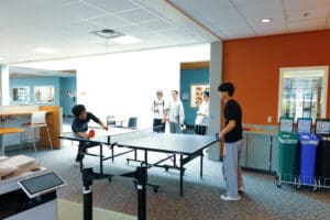 Students playing ping pong in the L building lobby