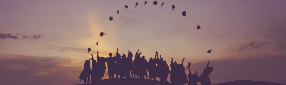 Stock photo of alumni throwing caps