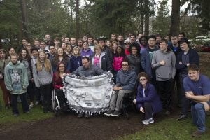 Larege group of OLS students holding blanket example and smiling