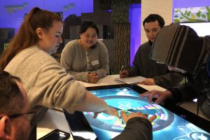 OLS Students interact with a large touchscreen at the Microsoft Museum