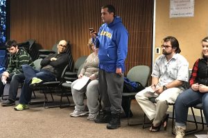 Adult student in blye Mariners sweatshirt presents to group