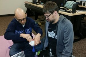 Two students fill stress ball balloons