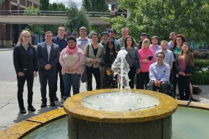 Group of OLS Students pose with two employees from Marriot Hotels outside the Marriot by their fountain