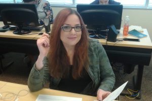 OLS Student smiling at camera sitting at desk