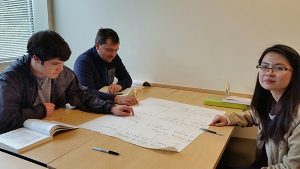 OLS Students work together brainstorming on a poster in class