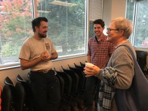 OLS Student smiles and talks with a visitor to the Coffee Social