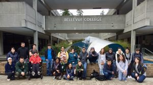 Students pose in a group shot in front of the Bellevue College campus fountain