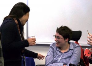OLS Student smiles and talks with a visitor to the Coffee Social