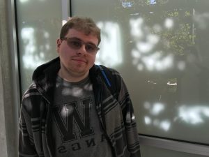 OLS Student smiles for the camera outside the north campus building