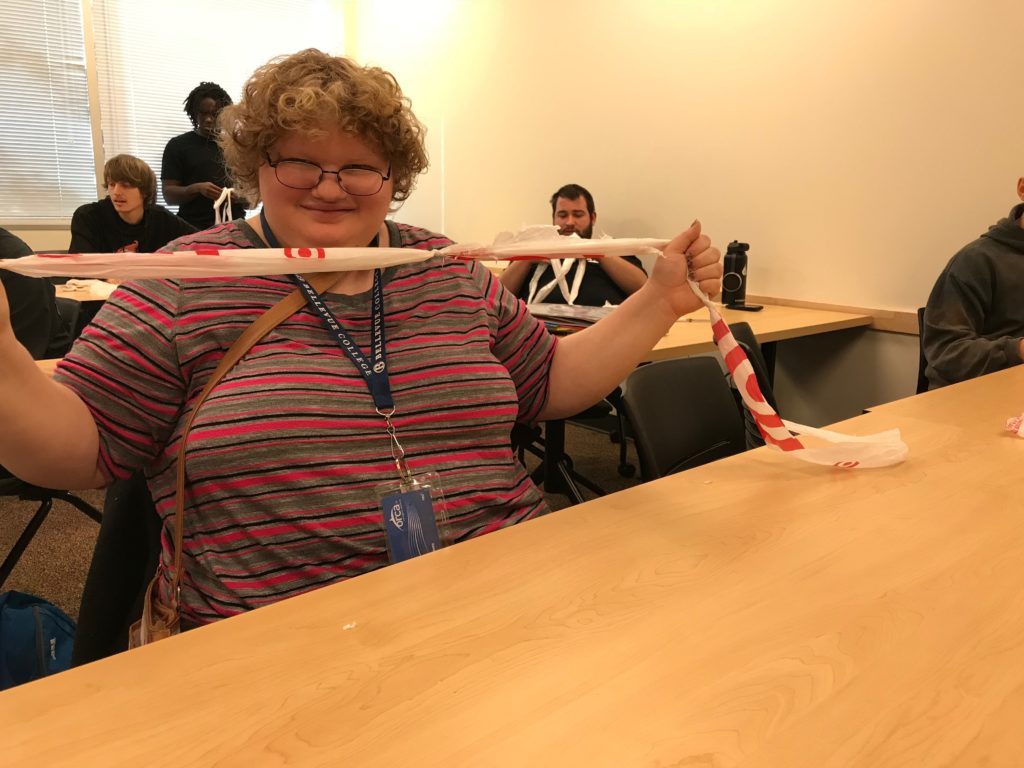 student proudly shows plarn made in class