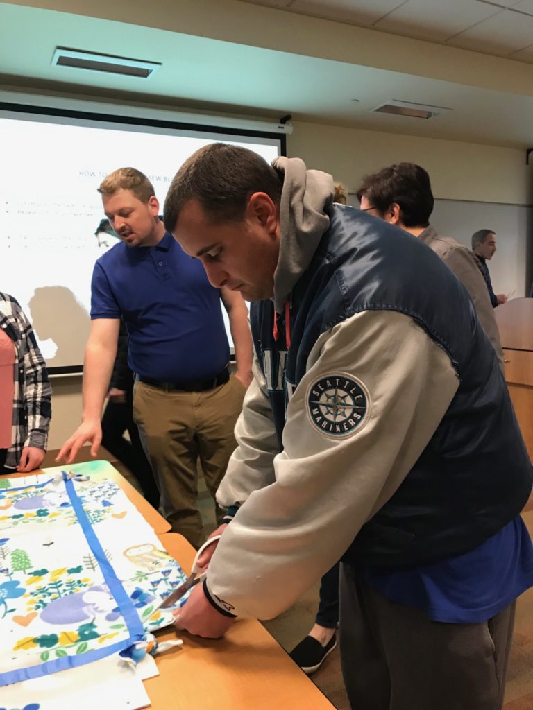 student cuts fabirc for blanket