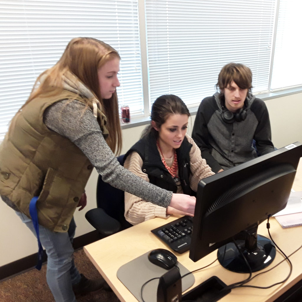 3 students working on a computer together