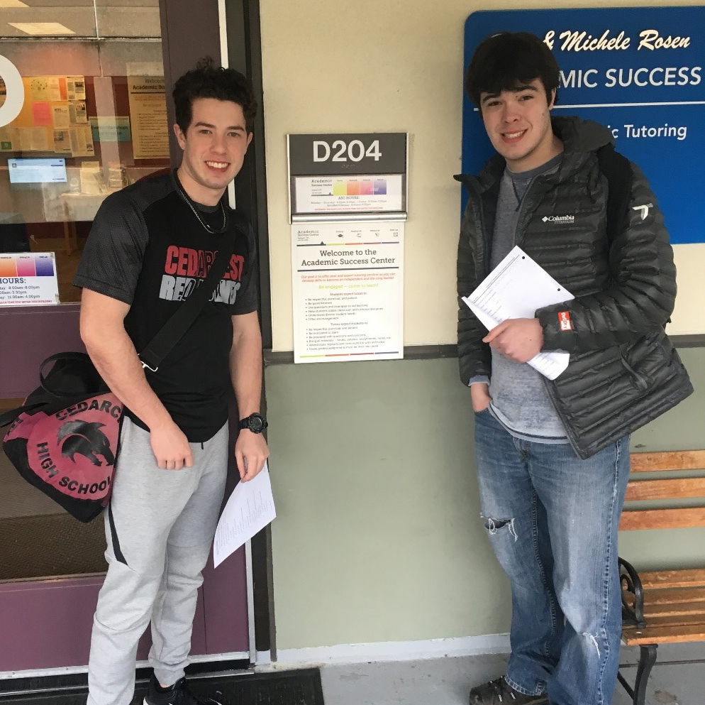 two students stand in front of a campus building