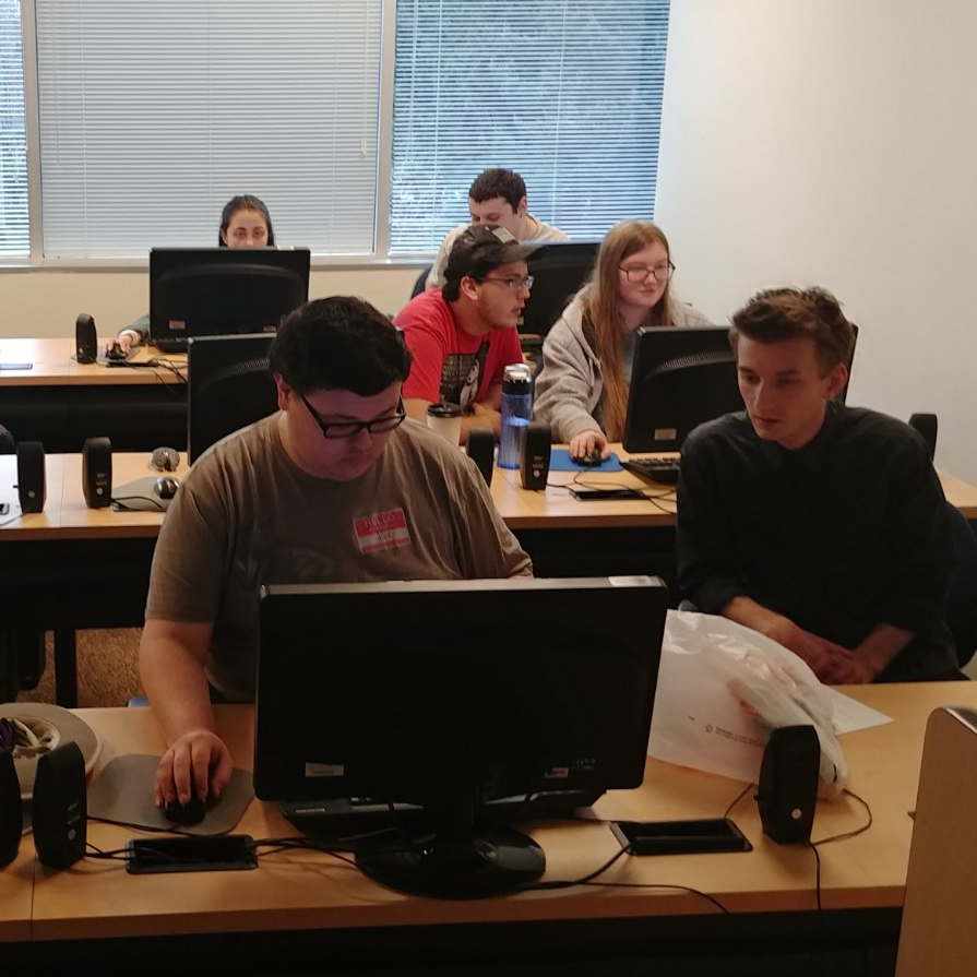 students work at computers in a classroom