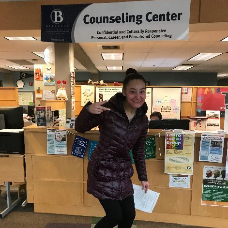 Female student poses in front of a couseling center sign