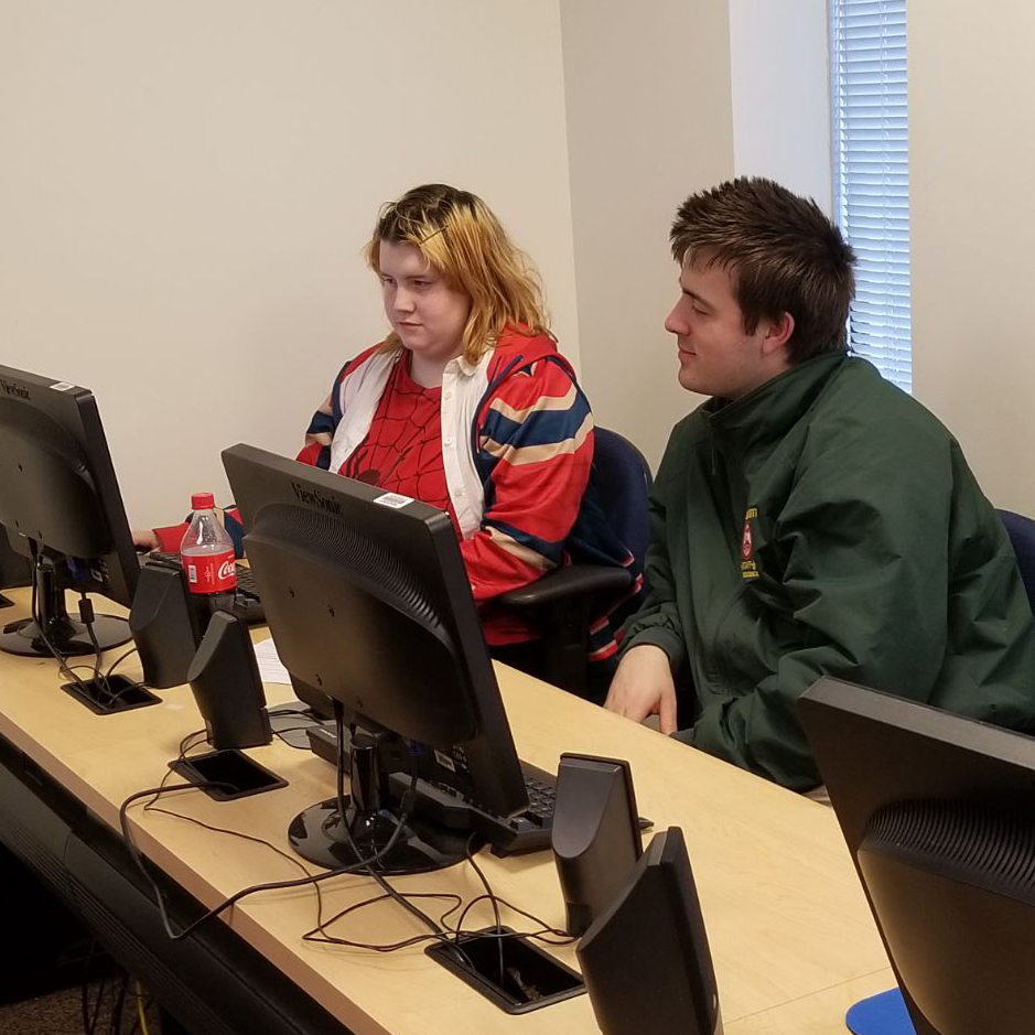 a male and a female students work together on a computer