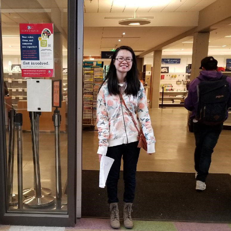 Female student stands in doorway of campus building