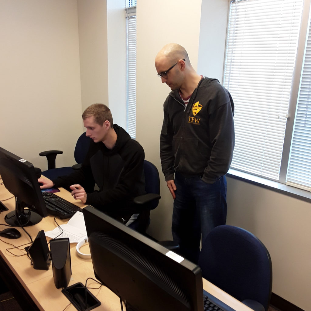 two students working at a computer together