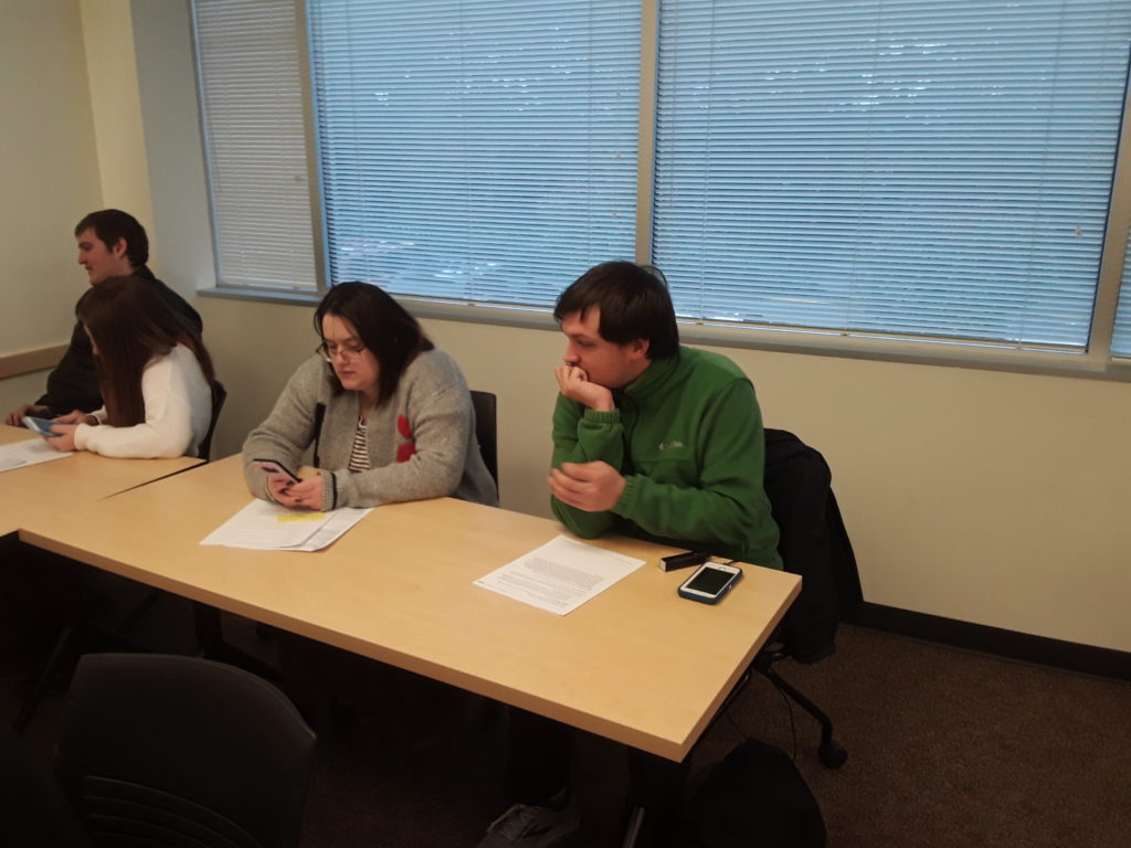 two young adult students dressed for job interviews sit at desks