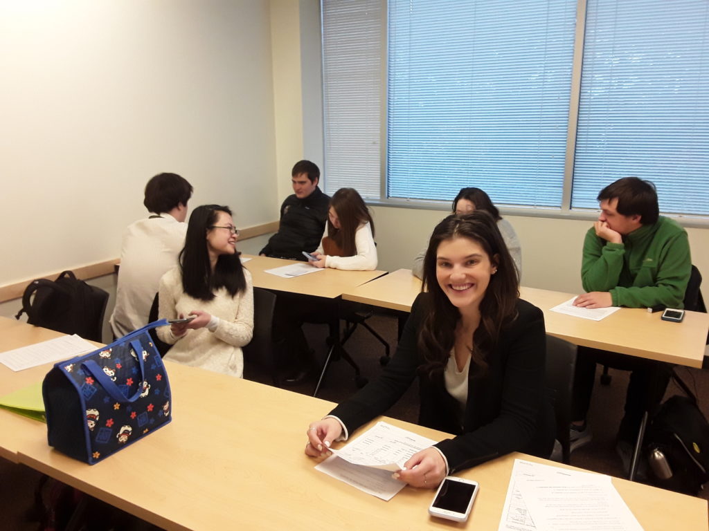 a groups of young adults dressed for job interviews sit at desks