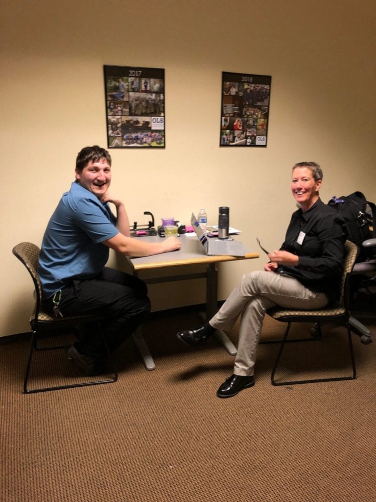 young man in blue shirt sits for an interview with a professional business woman