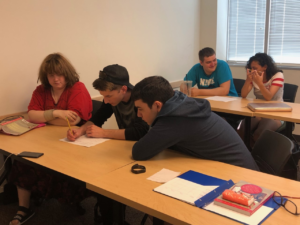 students sit at desks working on project